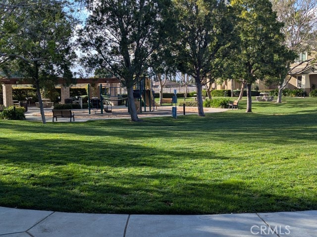 view of property's community with a lawn and playground community