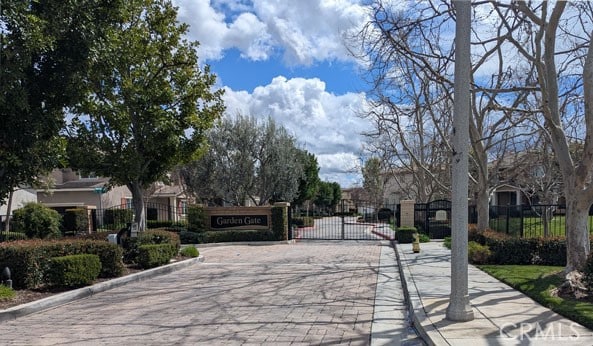 view of road featuring curbs, a gated entry, and a gate