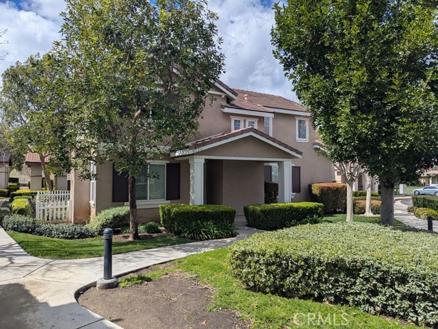 view of front of home with stucco siding and fence