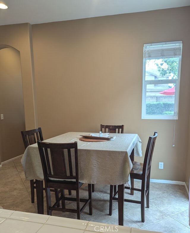 9770 Winterberry Dr, Riverside, CA 92803 - dining room with light tile patterned flooring, baseboards, and arched walkways