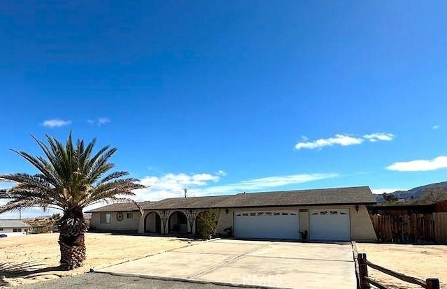 single story home featuring an attached garage, fence, and driveway