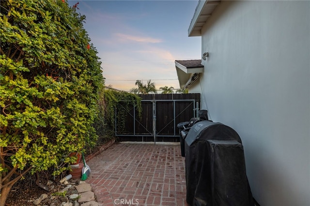 view of patio featuring a grill and fence