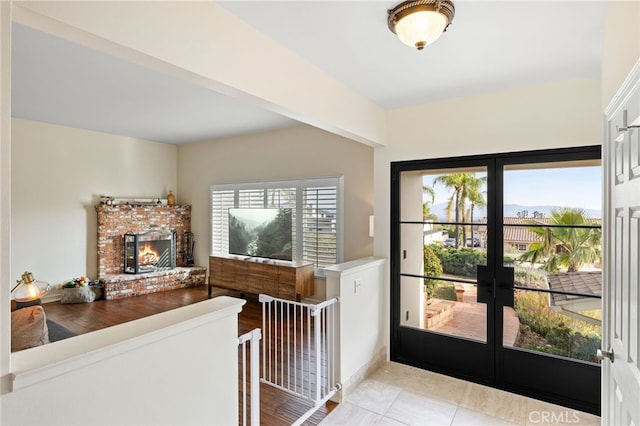 tiled entryway featuring french doors and a fireplace