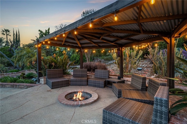 patio terrace at dusk with an outdoor living space with a fire pit and a gazebo