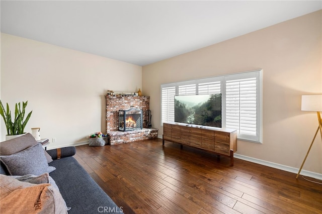 living room with baseboards, a fireplace, and hardwood / wood-style flooring