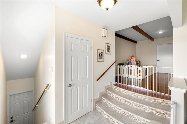 stairway with beamed ceiling