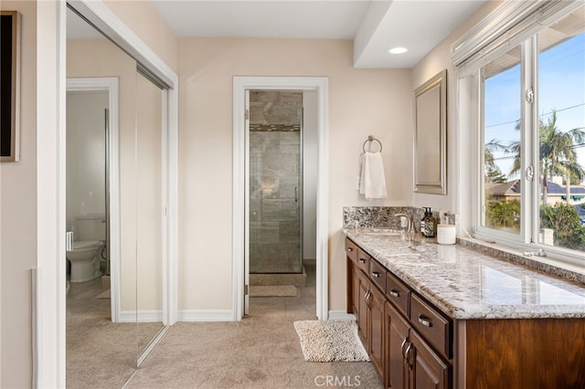 bathroom featuring vanity, baseboards, recessed lighting, a stall shower, and toilet