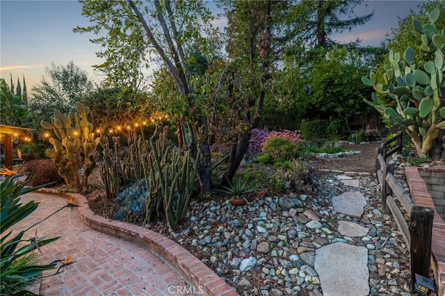 yard at dusk featuring a patio area