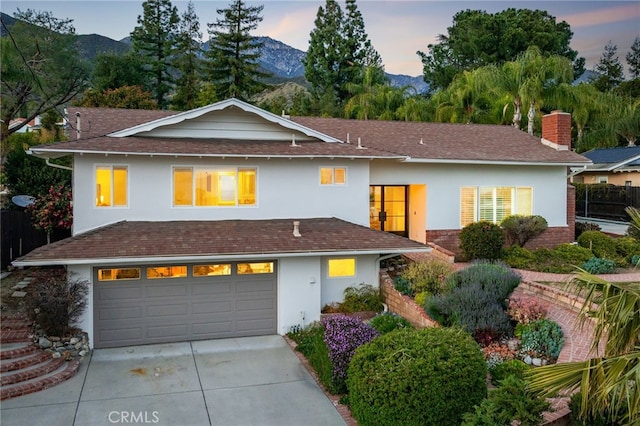 view of front of property with a mountain view, stucco siding, an attached garage, and concrete driveway