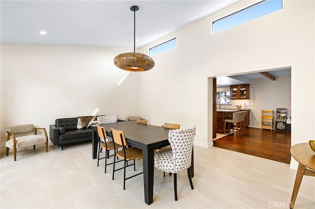 dining area featuring recessed lighting, baseboards, and a towering ceiling