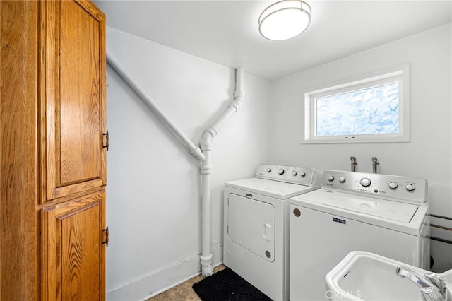 laundry room with washer and dryer, cabinet space, baseboards, and a sink