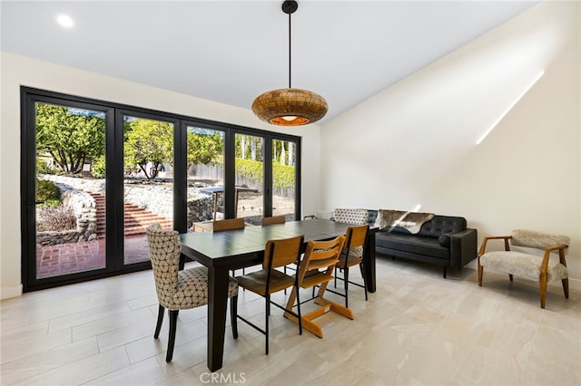 dining space with vaulted ceiling and baseboards