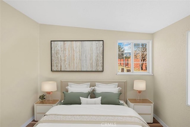 bedroom featuring baseboards and wood finished floors