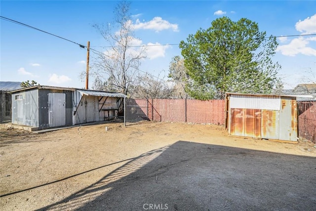 view of yard with an outbuilding, a fenced backyard, and a shed