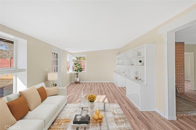 living area featuring baseboards and light wood finished floors