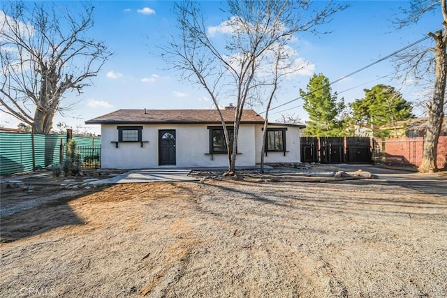 view of front facade with stucco siding and fence