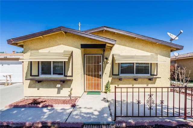 view of front of home featuring fence and stucco siding