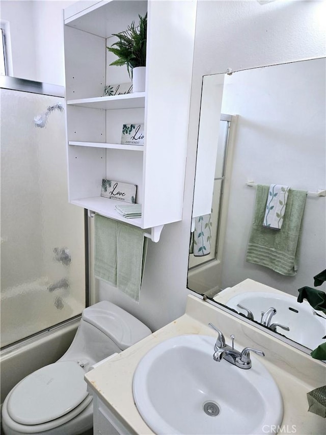 full bathroom with enclosed tub / shower combo, toilet, and vanity