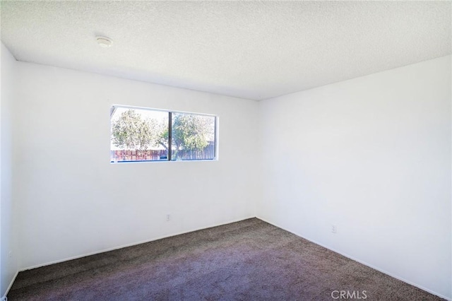 carpeted spare room with a textured ceiling