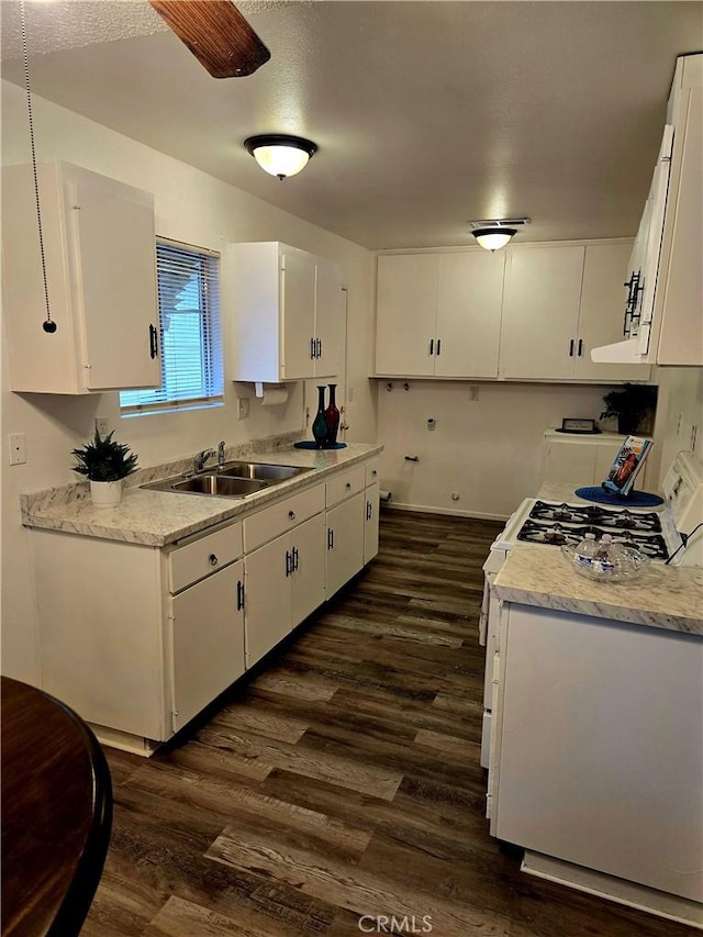 kitchen with dark wood-type flooring, white cabinets, light countertops, and a sink