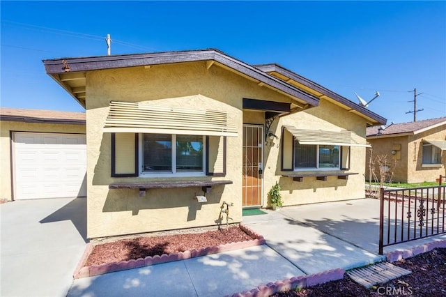 view of front of home featuring concrete driveway, a garage, and stucco siding