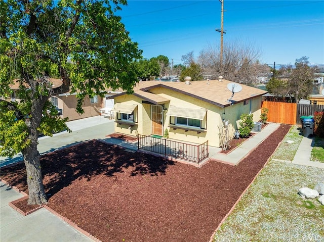 view of front of home with stucco siding and fence