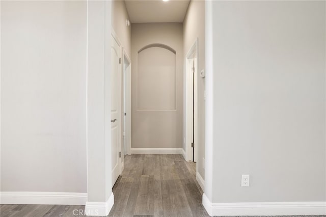 hall with baseboards and wood finished floors