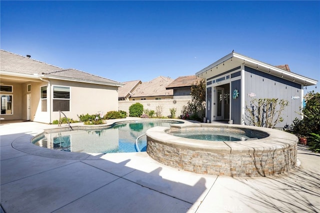 view of swimming pool with a pool with connected hot tub, a patio, and fence