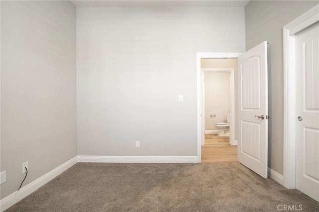 unfurnished bedroom with baseboards and carpet