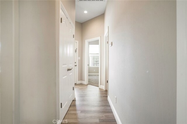 hall with visible vents, recessed lighting, baseboards, and wood finished floors