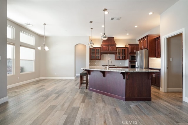 kitchen with a sink, arched walkways, visible vents, and stainless steel appliances