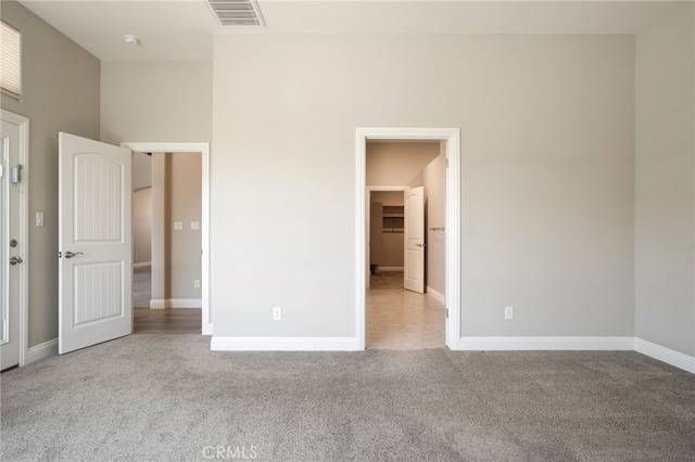 unfurnished bedroom with visible vents, carpet floors, and baseboards