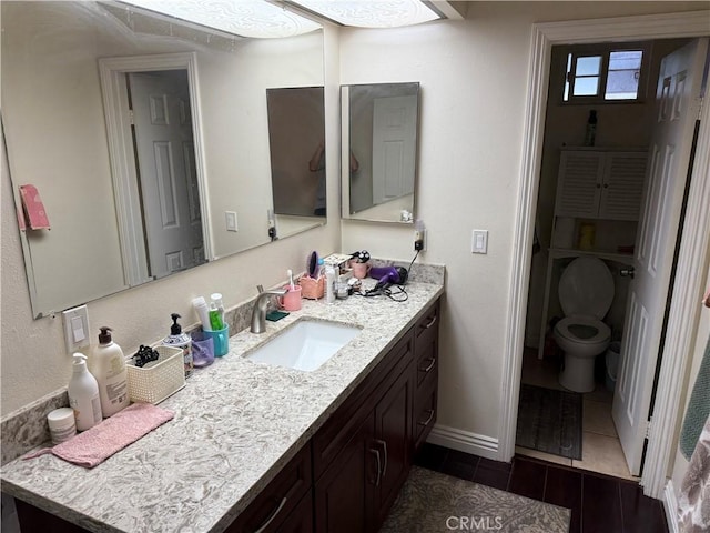 bathroom featuring vanity, baseboards, and wood finish floors