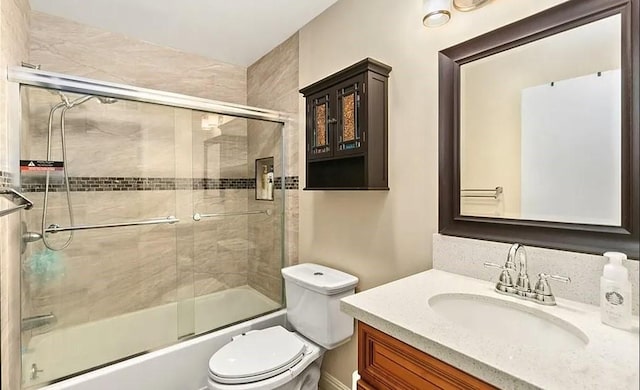 full bath with vanity, toilet, and combined bath / shower with glass door