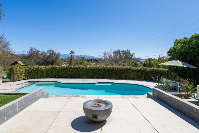 view of pool featuring a patio area, a fenced in pool, and a mountain view