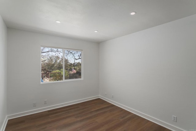 empty room featuring recessed lighting, dark wood-style floors, and baseboards