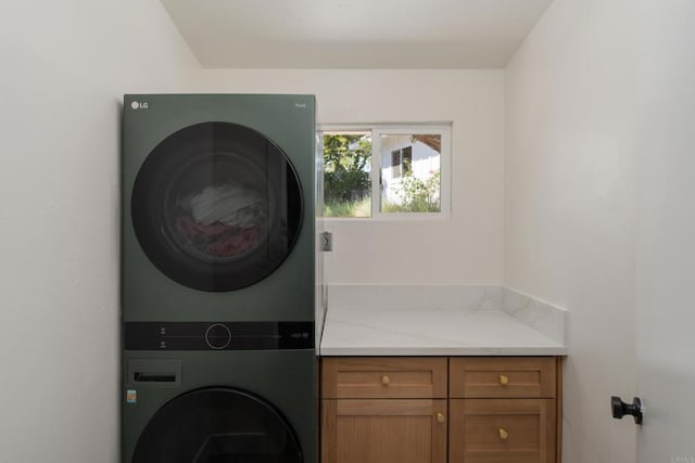 laundry area with cabinet space and stacked washer and dryer