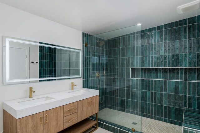 full bathroom featuring double vanity, walk in shower, and a sink