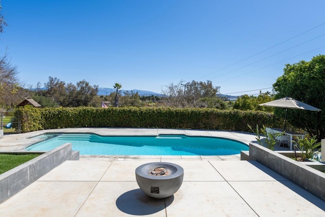 view of swimming pool featuring a fenced in pool, a mountain view, and a patio area