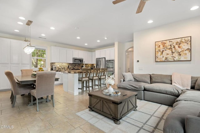 living area with arched walkways, recessed lighting, and a ceiling fan