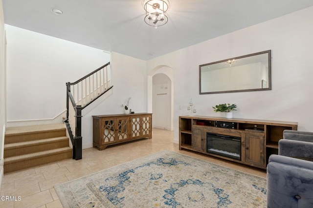 living room with stairway, arched walkways, and tile patterned flooring