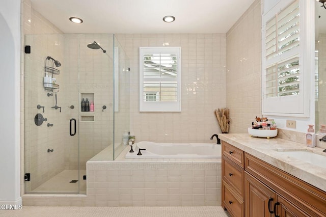 bathroom featuring a bath, plenty of natural light, a stall shower, and vanity