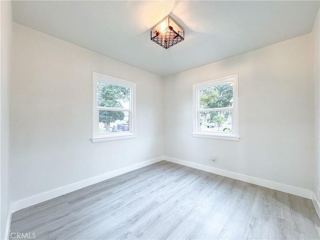 empty room with baseboards and light wood-style flooring