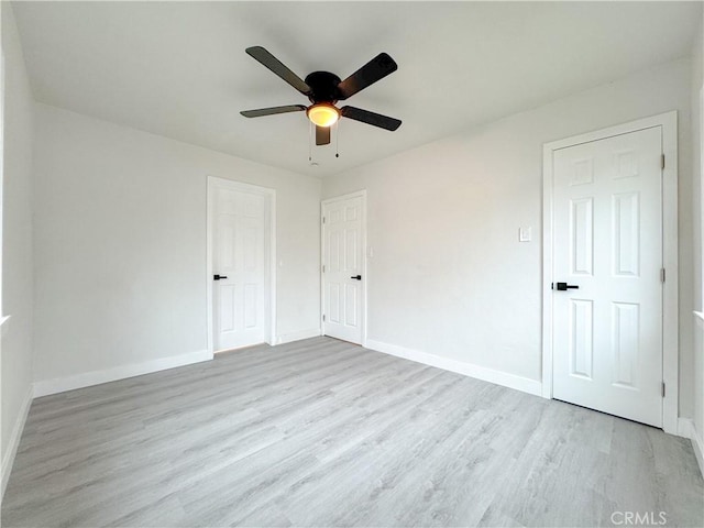 unfurnished bedroom with wood finished floors, baseboards, and ceiling fan