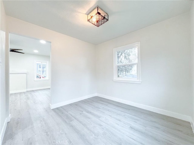 spare room with wood finished floors, baseboards, and a wealth of natural light