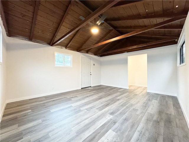 interior space featuring wooden ceiling, vaulted ceiling with beams, wood finished floors, and baseboards