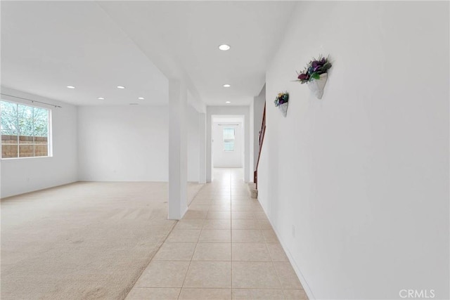 hall with recessed lighting, light colored carpet, and light tile patterned flooring