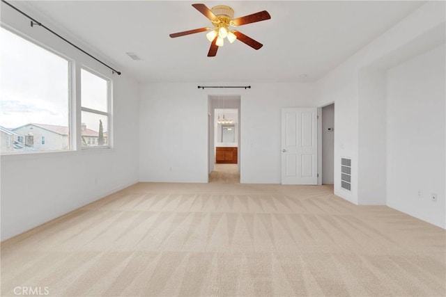 unfurnished room featuring ceiling fan with notable chandelier, visible vents, and light carpet