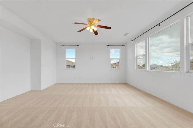 carpeted spare room with ceiling fan