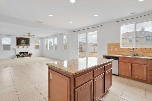 kitchen featuring a ceiling fan, a sink, tasteful backsplash, light tile patterned floors, and dishwasher